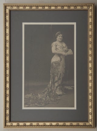 Large full-length photograph of the noted coloratura soprano in long dress with train, holding a fan, possibly a role portrait. With autograph inscription "Souvenir from Luisa Tetrazzini N.Y. 2 April 1911" in black ink running vertically along left portion of image.