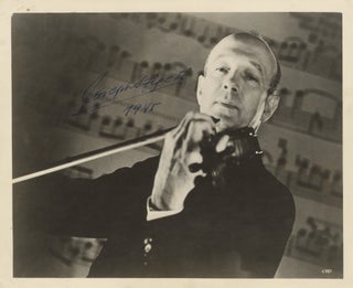 Item #39132 Half-length glossy publicity photograph of the noted violinist bowing his instrument....