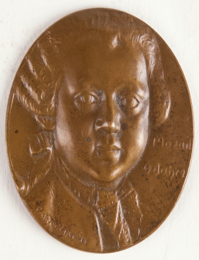 Item #40240 Bronze medal head-and-shoulders relief portrait of Mozart at 6 years of age. Designed by J. von Sepp Piffrader (1888-1952) after the earliest authentic image of Mozart, the oil painting by Pietro Antonio Lorenzini of 1763. Wolfgang Amadeus MOZART.
